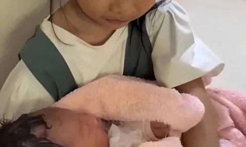 Xôn xao cảnh bé gái 6 tuổi xinh xắn ngồi ôm đứa bé sơ sinh ở hành lang bệnh viện, đau lòng chuyện phía sau