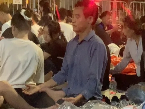 Người đàn ông tập yoga giữa biển người chờ xem diễu binh